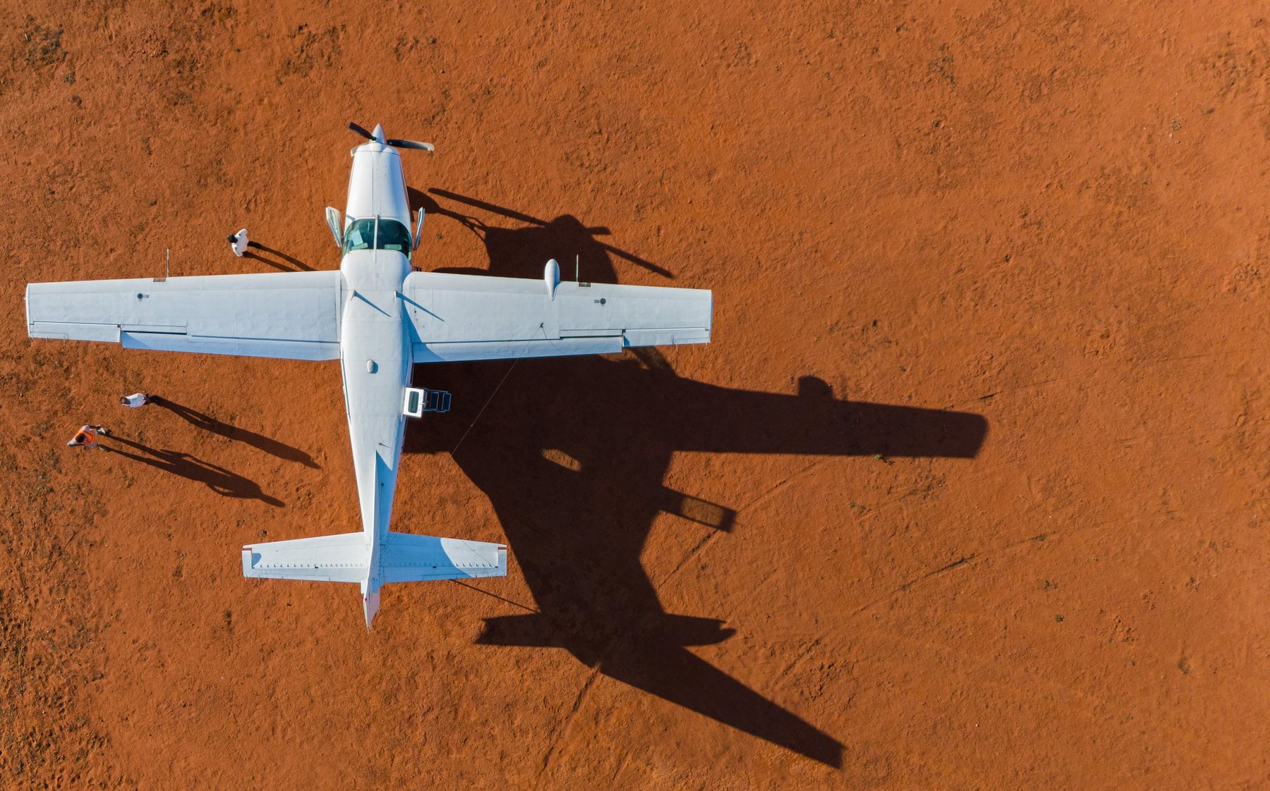 Avion de brousse vu du ciel, sur la terre rouge